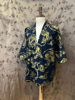 Load image into Gallery viewer, Navy blue jacket with gold patterns on a mannequin against a floral wallpaper background
